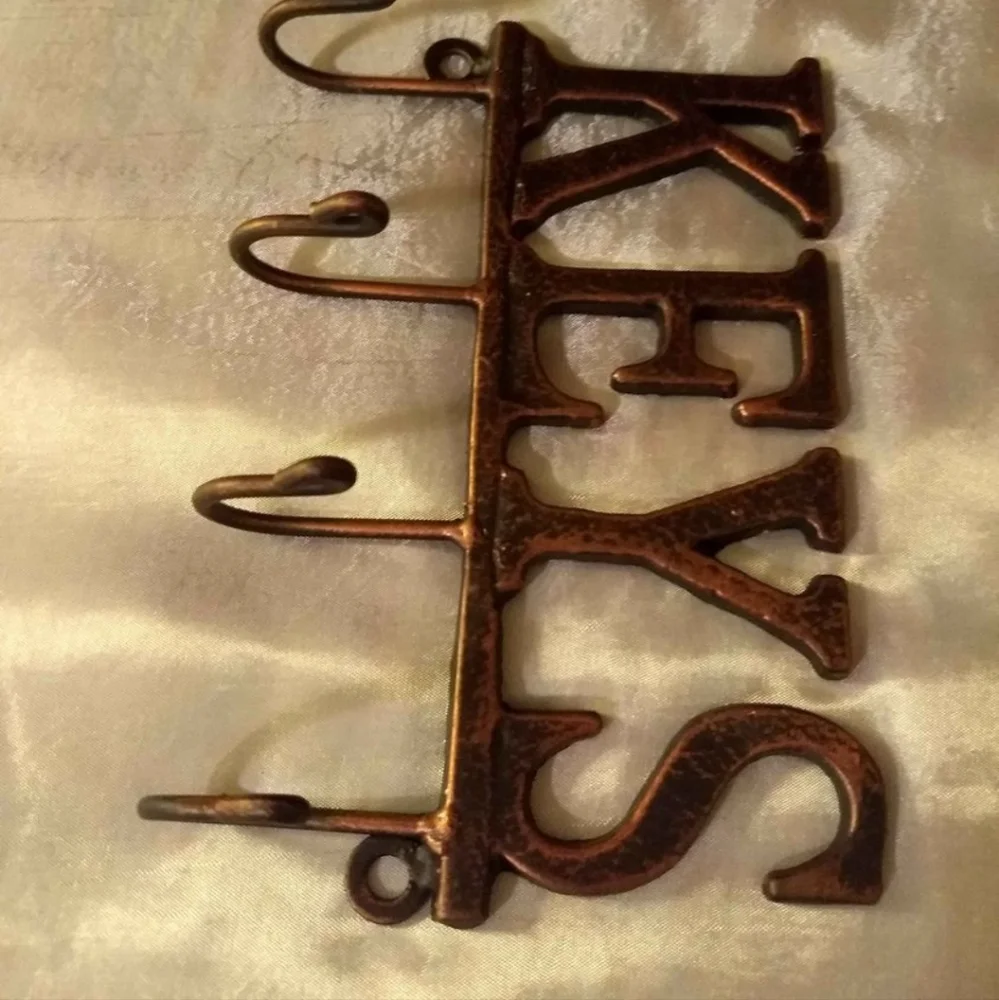 Metal Wall Mounted Key Rack With A Beautiful Black And Bronze Finish.